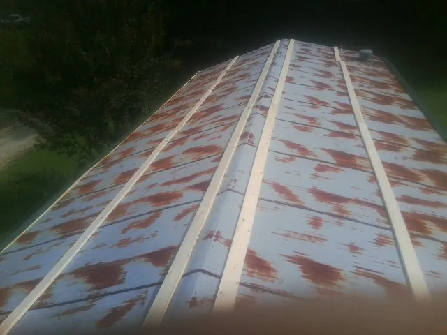 Rusted metal roof panels with new wood purlins before replacement — Storm Damage Roof Repair in College Point by Roofing Brothers