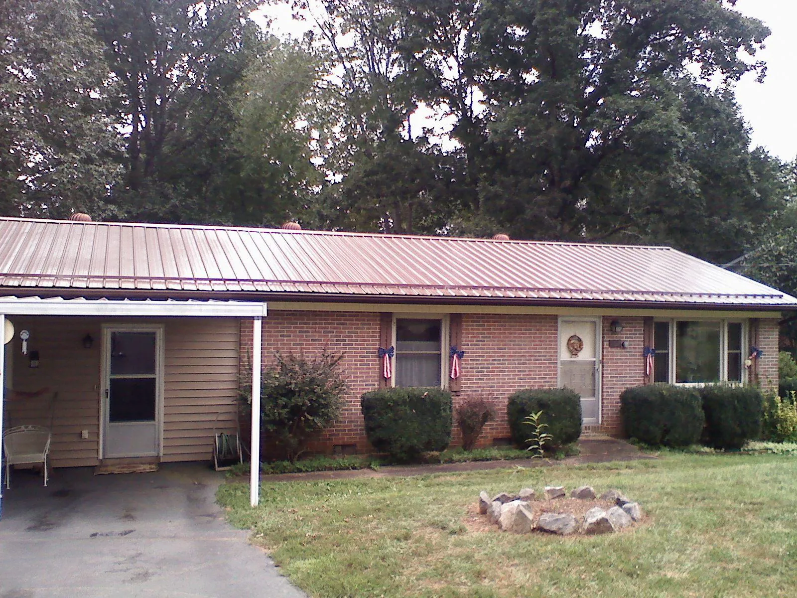 Bronze metal roof and carport on a brick ranch home — Roof Repair work by our crew in College Point